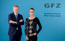 Dr. Stefan Schwartze und Prof. Susanne Buiter vor einer blauen Wand