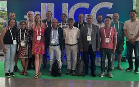 the 15 members of the IHFC in front of the IUGG logo, 3 women and 12 men