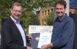 Dr. Ludwig Stroink (links) und Prof. Niels Hovius halten die Auszeichnung in den Händen. (Foto: GFZ)
