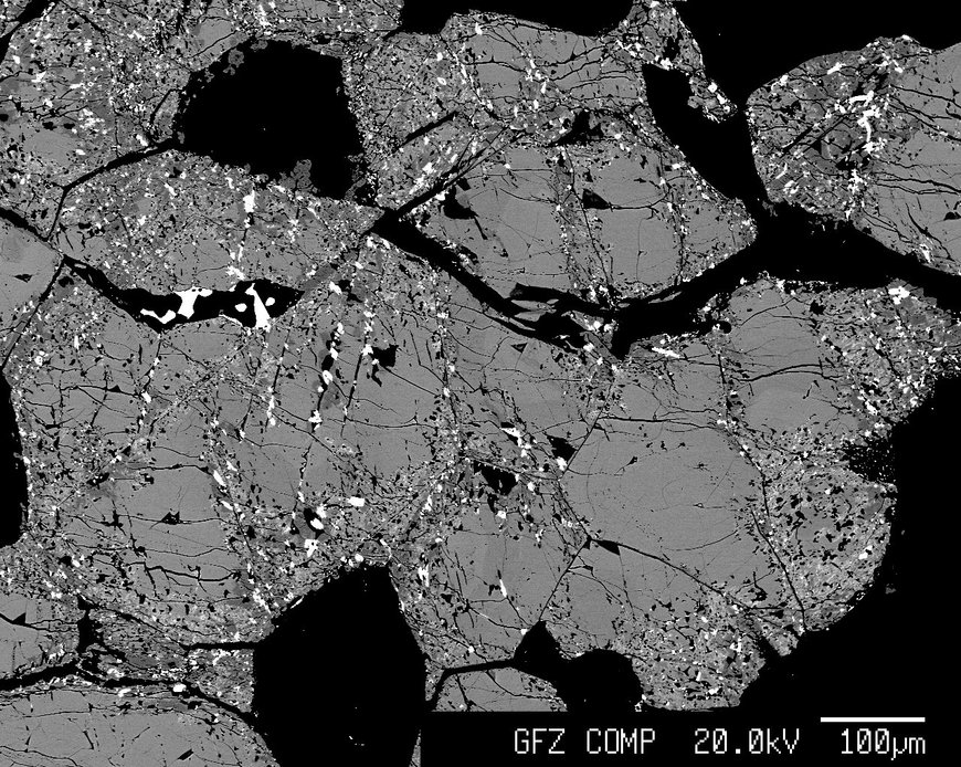 This figure represents a high contrast, backscattered, scanning electron image of monazite from the Steenkampskraal ore body. The monazite has been partially metasomatically altered by fluids resulting in the depletion of Th and the formation of huttonite (ThSiO4) inclusions in the altered areas along with an obvious porosity, which allowed for fluid infiltration via a coupled dissolution-reprecipitation process