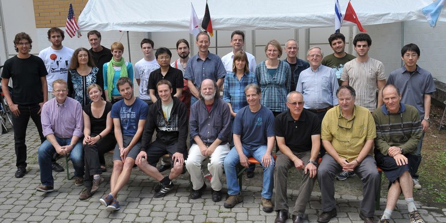 Group photo of 28 people in front of a neutral background on the Telegrafenberg in Potsdam.