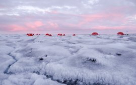 Eislandschaft mit fünf roten Zelten