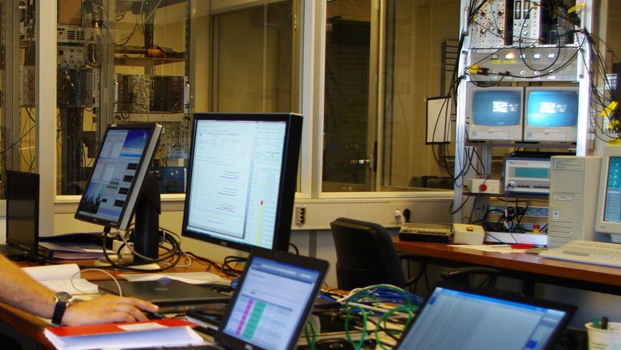 Figure 2: The photo shows the control room of a Cyclotron radiation source during a GNSS receiver test. On a table there are 3 computer displays which monitor the function of the GNSS-receiver under influence of strong radiation is monitored, using a specially adapted graphical user interface.