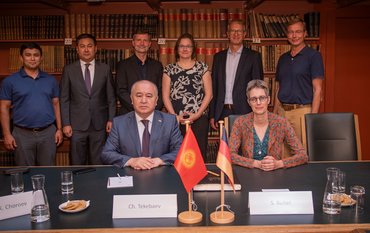 Gruppenfoto der Teilnehmenden in der historischen Bibliothek, zwischen historischen Büchern und Möbiliar.