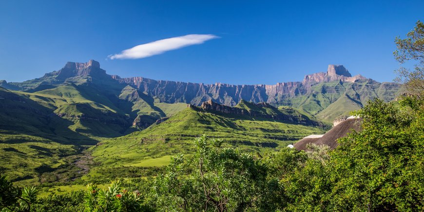 Nationalpark mit Wiesen im Vordergrund und gebirgsartigen Randstufe im Hintergrund ohne Pflanzenbewuchs, die sich quer durchs Bild zieht