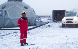 Martin Lipus steht im Schnee vor einem wissenschaftlichen Observatorium auf Island.