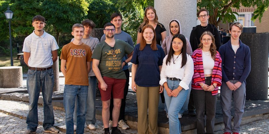 Group photo of 13 young people standing on the main site of the GFZ.